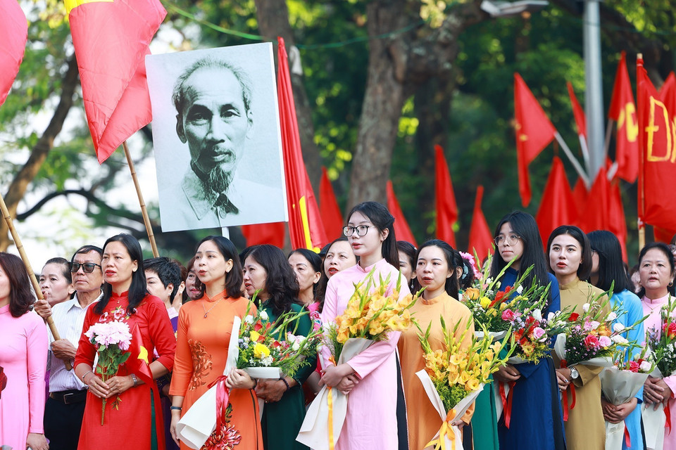 Quần chúng nhân dân chào cờ, hát quốc ca tái hiện lại buổi lễ chào cờ đầu tiên tại Hà Nội vào ngày 10/10/1954. (Ảnh: Dương Giang/TTXVN)