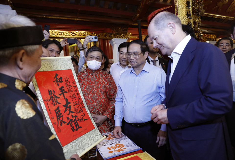 Thủ tướng Phạm Minh Chính giới thiệu bức thư pháp tới Thủ tướng Đức Olaf Scholz tại đền Ngọc Sơn. (Ảnh: An Đăng/TTXVN)