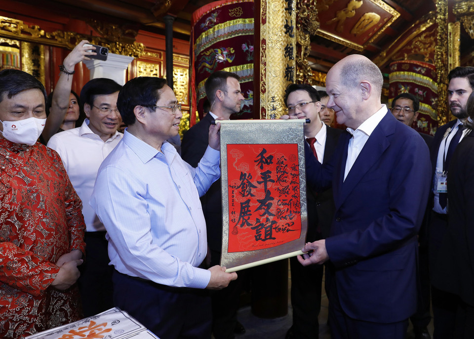 Thủ tướng Phạm Minh Chính tặng Thủ tướng Đức Olaf Scholz bức thư pháp với nội dung "Hòa bình - Hữu nghị cùng phát triển" tại đền Ngọc Sơn. (Ảnh: An Đăng/TTXVN)