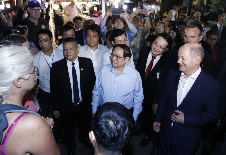 Thủ tướng Phạm Minh Chính và Thủ tướng Đức Olaf Scholz trò chuyện với khách quốc tế tại khu vực bờ hồ Hoàn Kiếm.(Ảnh: An Đăng/TTXVN)