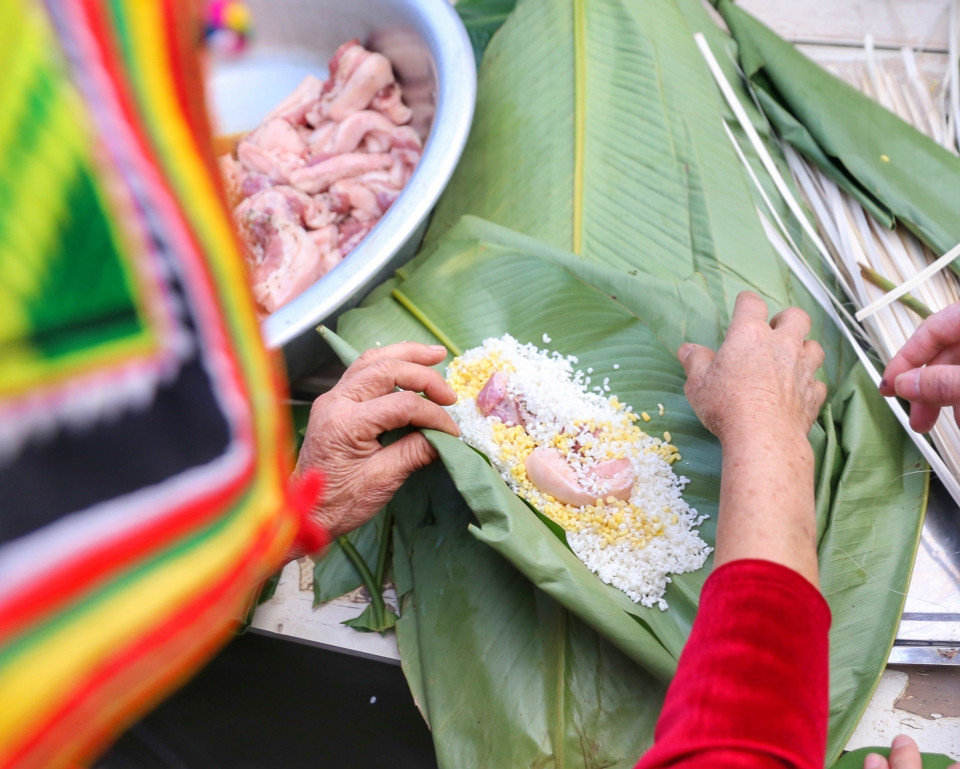 Đồng bào dân tộc Thái tham gia gói bánh chưng Tết. (Ảnh: Tuấn Đức/TTXVN)