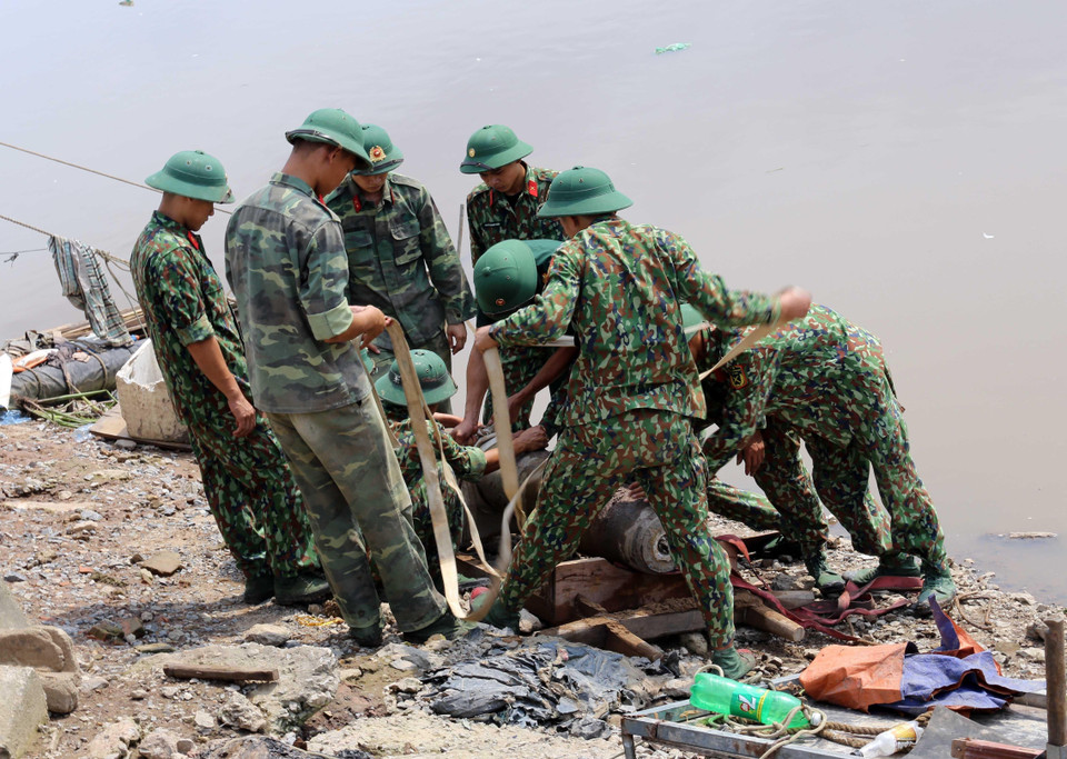 Các lực lượng chức năng di dời quả bom tại khu vực cầu mới sông Tam Bạc, khu vực phường Hạ Lý, quận Hồng Bàng tới nơi hủy nổ. (Ảnh: An Đăng/TTXVN)