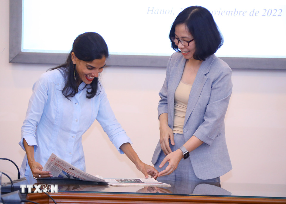 Phó Tổng Biên tập báo Granma (Cuba) Arlin Alberty Loforte giới thiệu một ấn phẩm báo chí của Cuba với Tổng Giám đốc Thông tấn xã Việt Nam Vũ Việt Trang. (Ảnh: Văn Điệp/TTXVN)