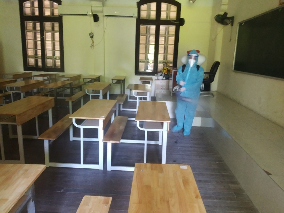 Tại điểm thi Trường THPT Phan Đình Phùng (quận Ba Đình, Hà Nội) nhân viên y tế phun khử khuẩn toàn bộ khuôn viên điểm thi ngay sau khi thí sinh đến làm thủ tục và nhận phòng thi. (Ảnh: PV/Vietnam+)