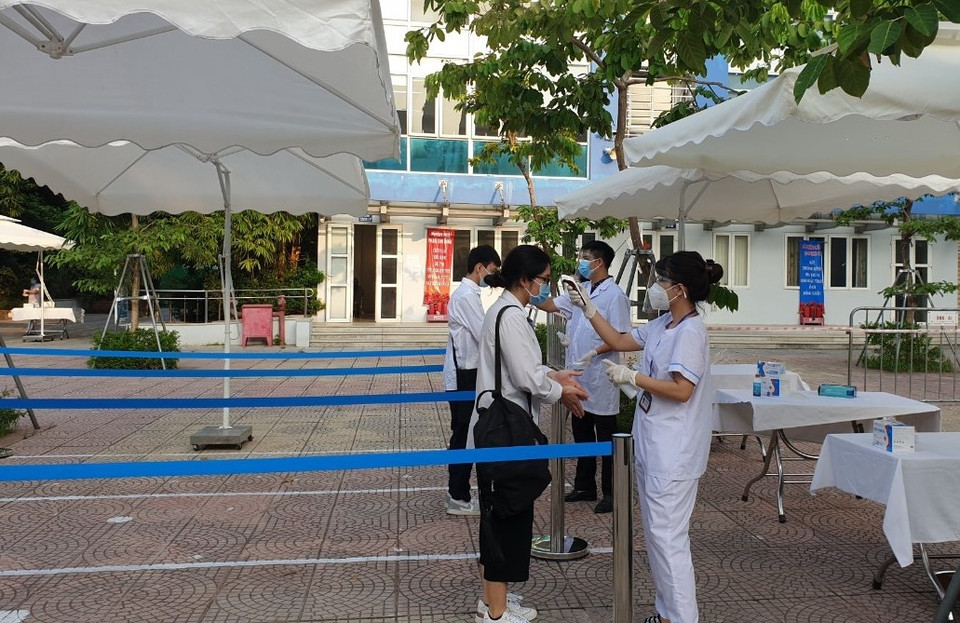 Tại các điểm thi, thí sinh đều được lực lượng y tế đo thân nhiệt, rửa tay sát khuẩn trước khi bước vào phòng thi. (Ảnh: PV/Vietnam+)