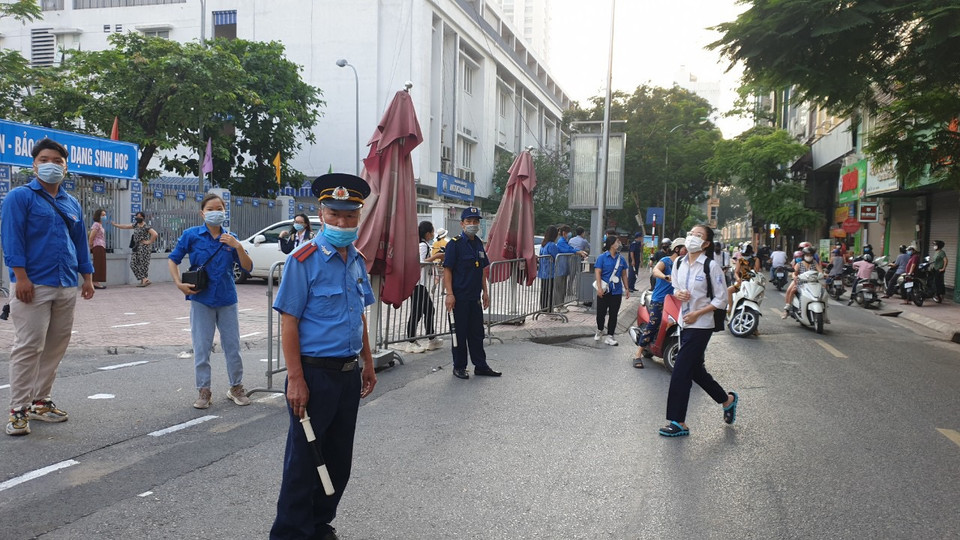 Lực lượng chức năng túc trực bên ngoài địa điểm thi để phân luồng giao thông, tránh để xảy ra tình trạng ách tắc các phương tiện. (Ảnh: PV/Vietnam+)
