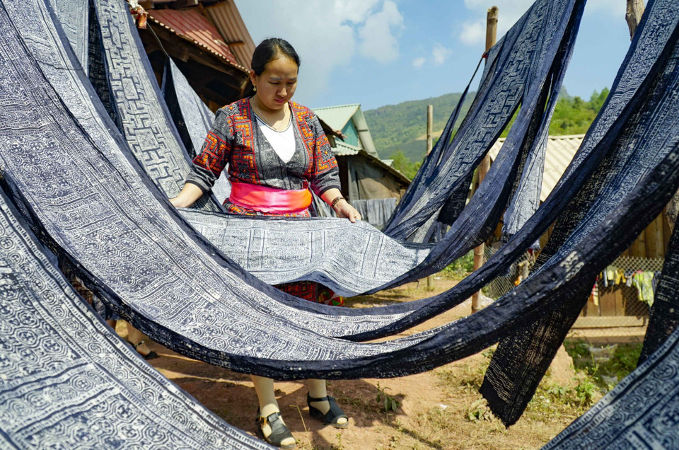 Vải sau khi nhuộm được mang đi phơi nắng. (Ảnh: Xuân Tư/TTXVN)