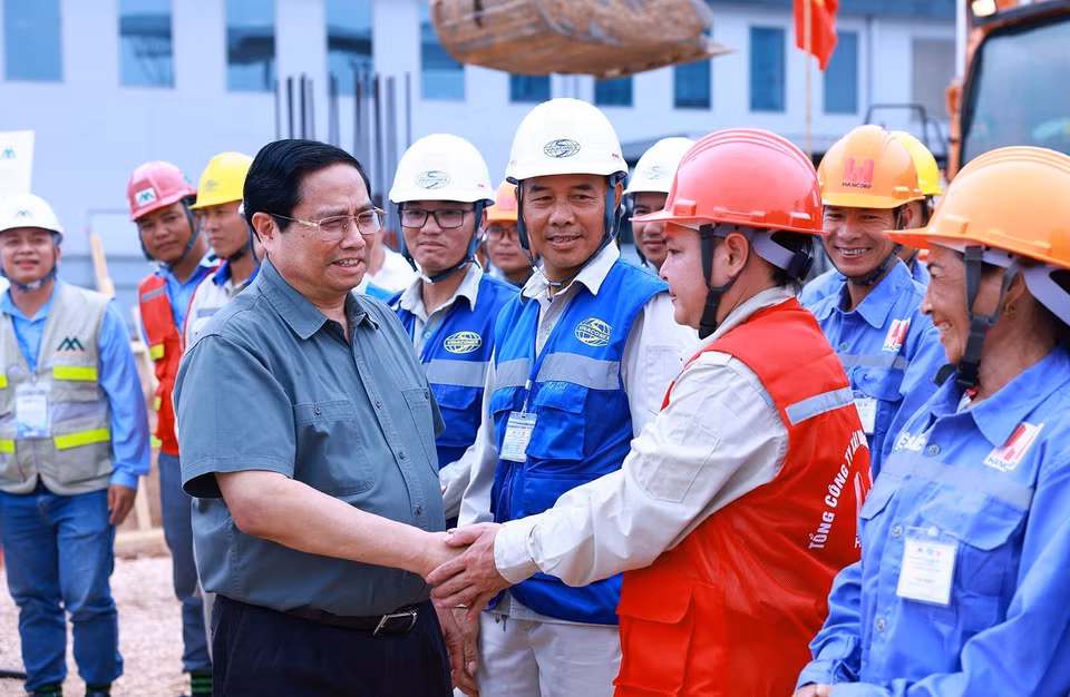 Thủ tướng Phạm Minh Chính với công nhân thi công dự án. (Ảnh: Dương Giang/TTXVN)