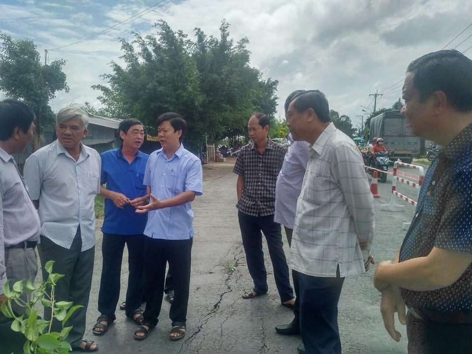 Đoàn công tác của tỉnh khảo sát thực tế tại khu vực xuất hiện vết rạn nứt trên Quốc lộ 91 đoạn đi qua ấp Bình Tân, xã Bình Mỹ, huyện Châu Phú, tỉnh An Giang có nguy cơ sạt lở xuống sông Hậu. (Ảnh: Công Mạo/TTXVN)