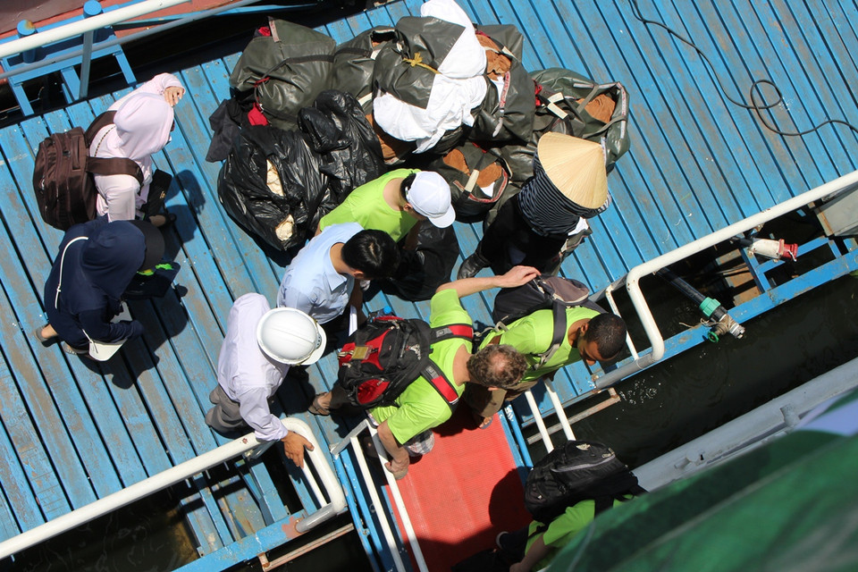 Di chuyển lên tàu ra đảo thu gom rác. (Ảnh: Hùng Võ/Vietnam+)