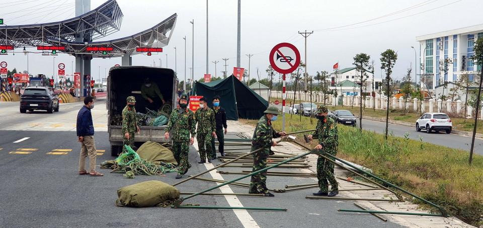  Lực lượng chức năng dựng lán chuẩn bị cho công tác phòng chống COVID-19 tại chốt trạm cầu Bạch Đằng, thị xã Quảng Yên. (Ảnh: TTXVN)