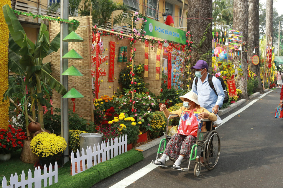 Bệnh nhân và người nhà bệnh nhân tham quan Đường hoa Xuân trong khuôn viên Bệnh viện Chợ Rẫy. (Ảnh: Đinh Hằng/TTXVN)