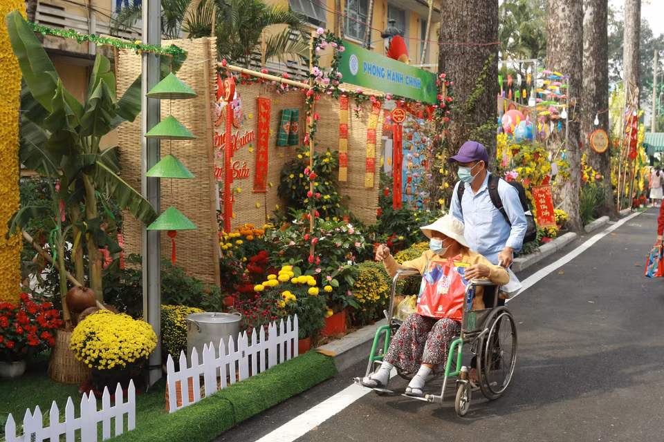 Bệnh nhân và người nhà bệnh nhân tham quan Đường hoa Xuân trong khuôn viên Bệnh viện Chợ Rẫy. (Ảnh: Đinh Hằng/TTXVN)