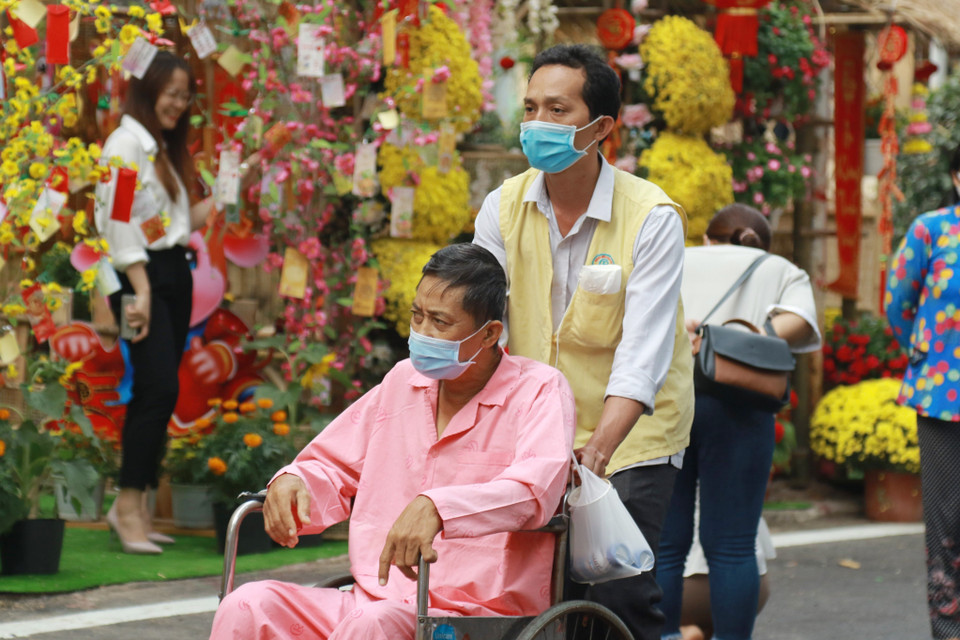 Bệnh nhân và người nhà bệnh nhân tham quan Đường hoa Xuân trong khuôn viên Bệnh viện Chợ Rẫy. (Ảnh: Đinh Hằng/TTXVN)