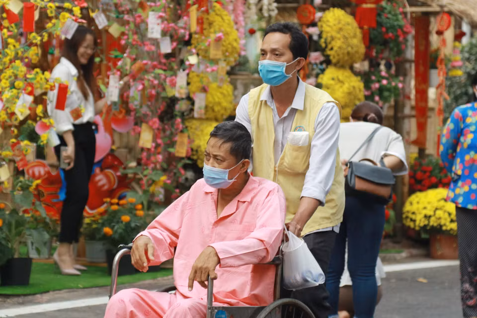 Bệnh nhân và người nhà bệnh nhân tham quan Đường hoa Xuân trong khuôn viên Bệnh viện Chợ Rẫy. (Ảnh: Đinh Hằng/TTXVN)