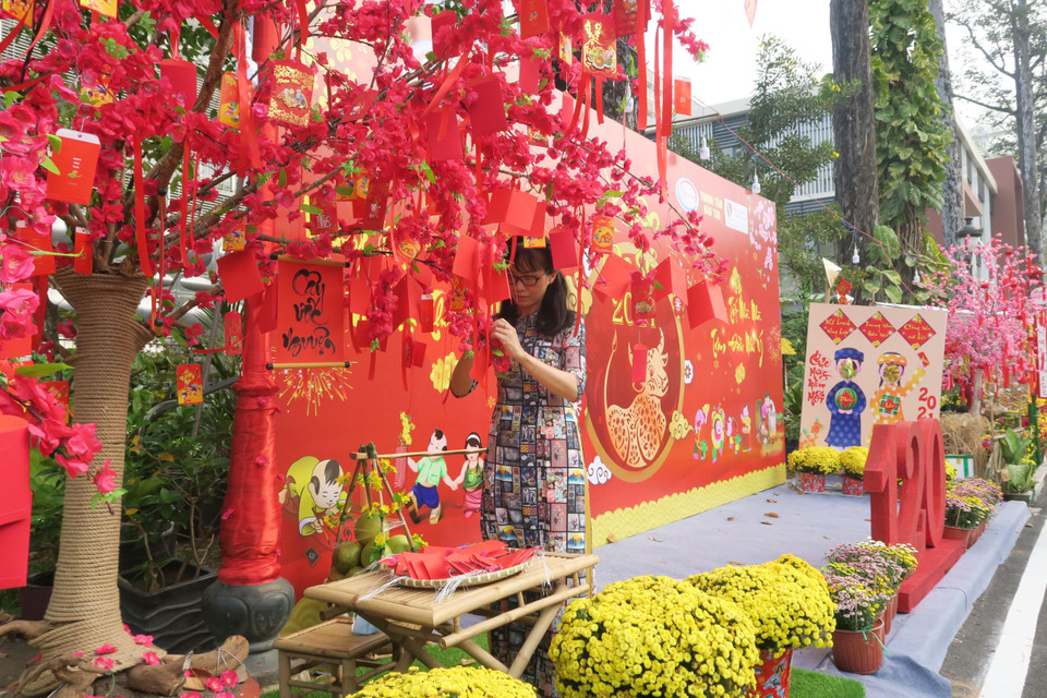 Một nhân viên bệnh viện gửi điều ước lên Cây ước nguyện trên Đường hoa Xuân. (Ảnh: Đinh Hằng/TTXVN)