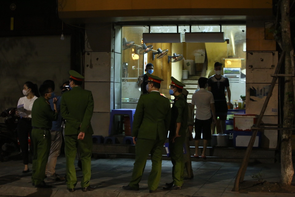 Lực lượng chức năng phường Nguyễn Du đến nhắc nhở các cửa hàng thực hiện đóng cửa theo quy định.(Ảnh: Minh Quyết/TTXVN)