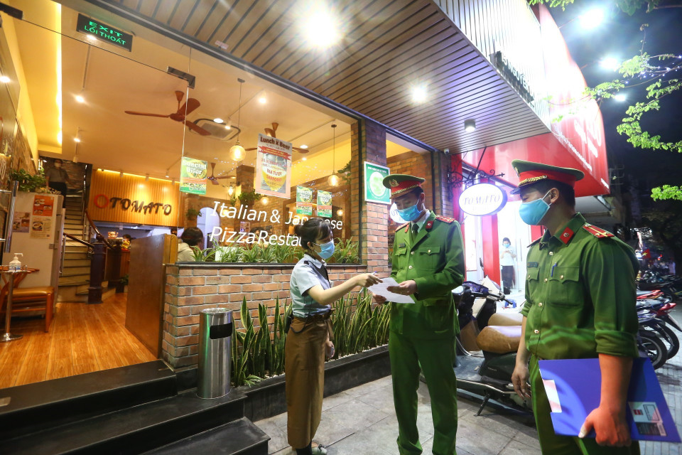 Lực lượng chức năng phường Nguyễn Du đến nhắc nhở các cửa hàng thực hiện đóng cửa theo quy định. (Ảnh: Minh Quyết/TTXVN)