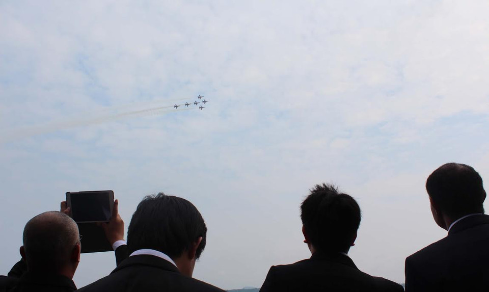 Khán giả chăm chú xem máy bay chiến đấu của quân Singapore thưc hiện pha trình diễn