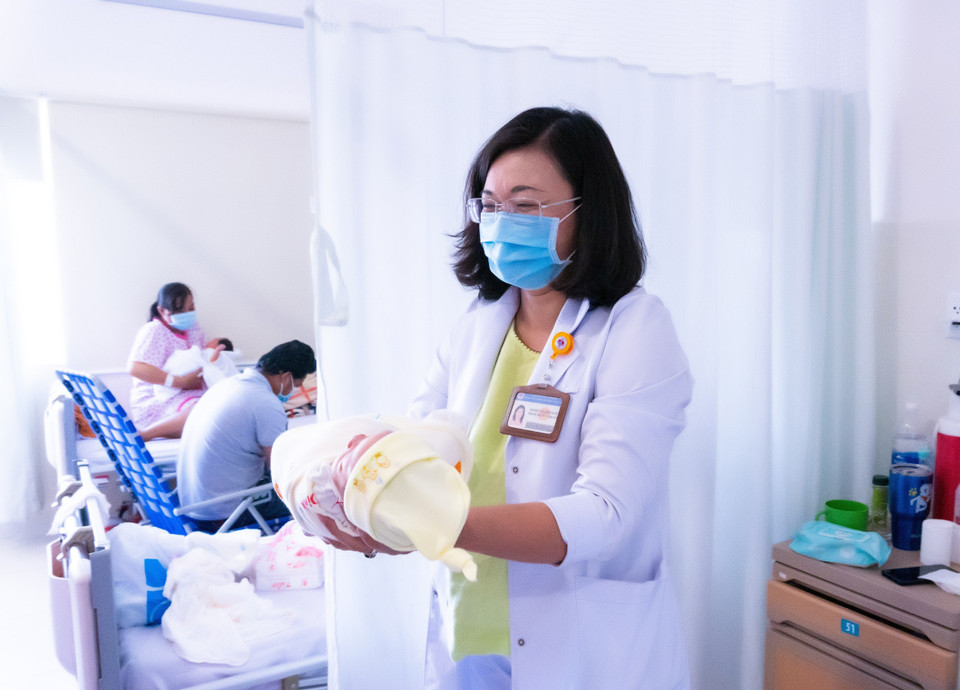 Phó Giáo sư, Tiến sỹ, bác sỹ Hoàng Thị Diễm Tuyết, Giám đốc Bệnh viện Hùng Vương và bé gái nhờ mang thai hộ vì mục đích nhân đạo đầu tiên. (Ảnh: TTXVN phát)