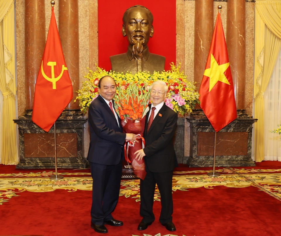 Chủ tịch nước Nguyễn Xuân Phúc tặng hoa Tổng Bí thư Nguyễn Phú Trọng, nguyên Chủ tịch nước. (Ảnh: Trí Dũng/TTXVN)