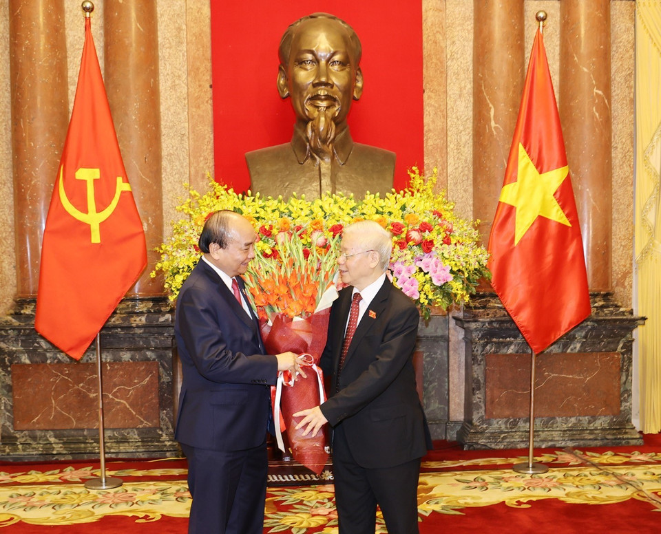 Chủ tịch nước Nguyễn Xuân Phúc tặng hoa Tổng Bí thư Nguyễn Phú Trọng, nguyên Chủ tịch nước. (Ảnh: Trí Dũng/TTXVN)