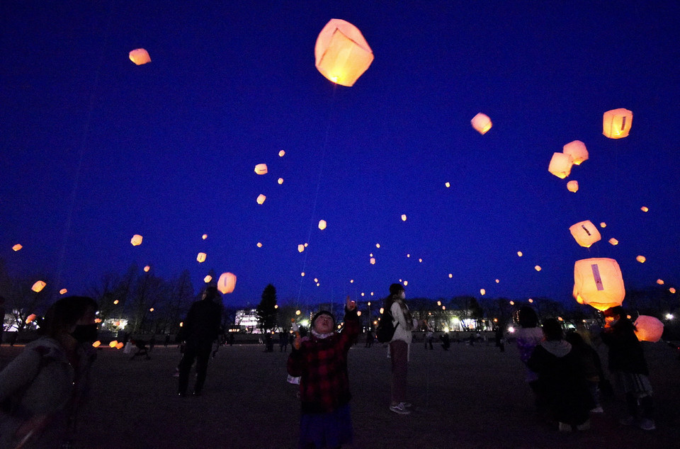 Tròn 10 năm sau thảm họa động đất và sóng thần tại vùng Đông Bắc vào ngày 11/3/2011, Nhật Bản đã nỗ lực tái thiết và phục hồi những khu vực bị tàn phá. Trong ảnh: Người dân thả đèn lồng tưởng niệm các nạn nhân trong thảm họa động đất và sóng thần năm 2011, tại Tokyo, Nhật Bản, ngày 11/3/2021. (Ảnh: AFP/TTXVN)