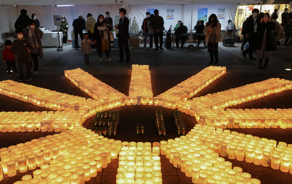 Tròn 10 năm sau thảm họa động đất và sóng thần tại vùng Đông Bắc vào ngày 11/3/2011, Nhật Bản đã nỗ lực tái thiết và phục hồi những khu vực bị tàn phá. Trong ảnh: Người dân thắp đèn lồng tưởng niệm các nạn nhân trong thảm họa động đất và sóng thần năm 2011, tại Tokyo, Nhật Bản, ngày 11/3/2021. (Ảnh: THX/TTXVN)