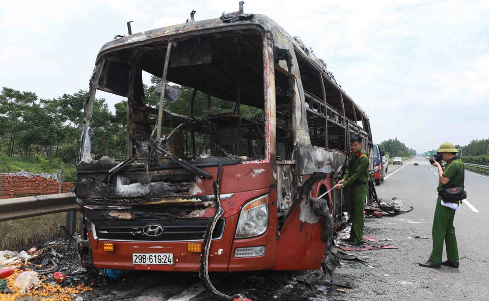 Lực lượng chức năng làm nhiệm vụ ở hiện trường vụ cháy ôtô trên cao tốc Nội Bài-Lào Cai. (Ảnh: Hoàng Hùng/TTXVN)