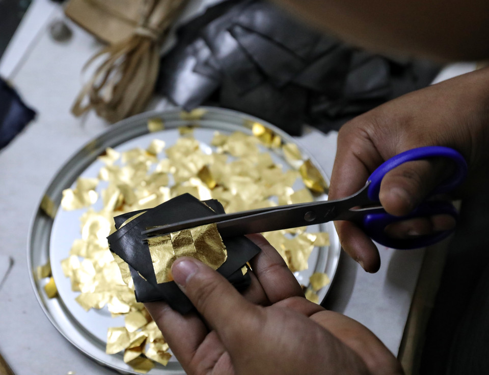 Các công đoạn xếp vàng chuẩn bị cho khâu đập điệp và làm quỳ cũ đòi hỏi sự kiên trì và tỉ mỉ cao. (Ảnh: Danh Lam/TTXVN)