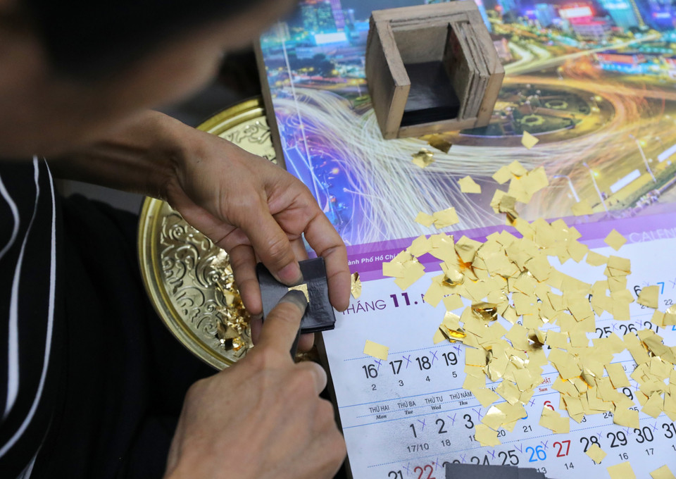 Các công đoạn xếp vàng chuẩn bị cho khâu đập điệp và làm quỳ cũ đòi hỏi sự kiên trì và tỉ mỉ cao. (Ảnh: Danh Lam/TTXVN)