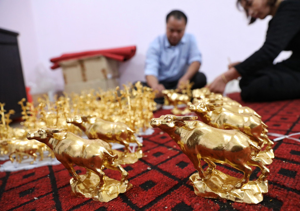 Sản phẩm trâu vàng Tân Sửu 2021 được gia đình nghệ nhân Nguyễn Anh Chung thếp vàng theo đơn đặt hàng. (Ảnh: Danh Lam/TTXVN)