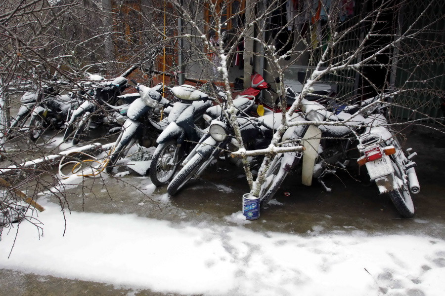  Tuyết rơi trắng trên các phương tiện xe máy để ngoài trời. (Ảnh: Thế Duyệt/TTXVN)