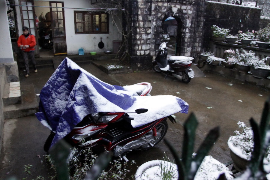 Tuyết rơi trắng trên các phương tiện xe máy để ngoài trời. (Ảnh: Thế Duyệt/TTXVN)