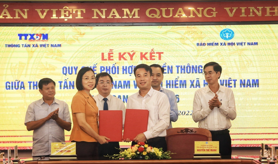 Tổng Giám đốc Thông tấn xã Việt Nam Vũ Việt Trang và Tổng Giám đốc Bảo hiểm xã hội Việt Nam Nguyễn Thế Mạnh trao đổi biên bản ký kết hợp tác tại buổi lễ. (Ảnh: Tuấn Anh/TTXVN)