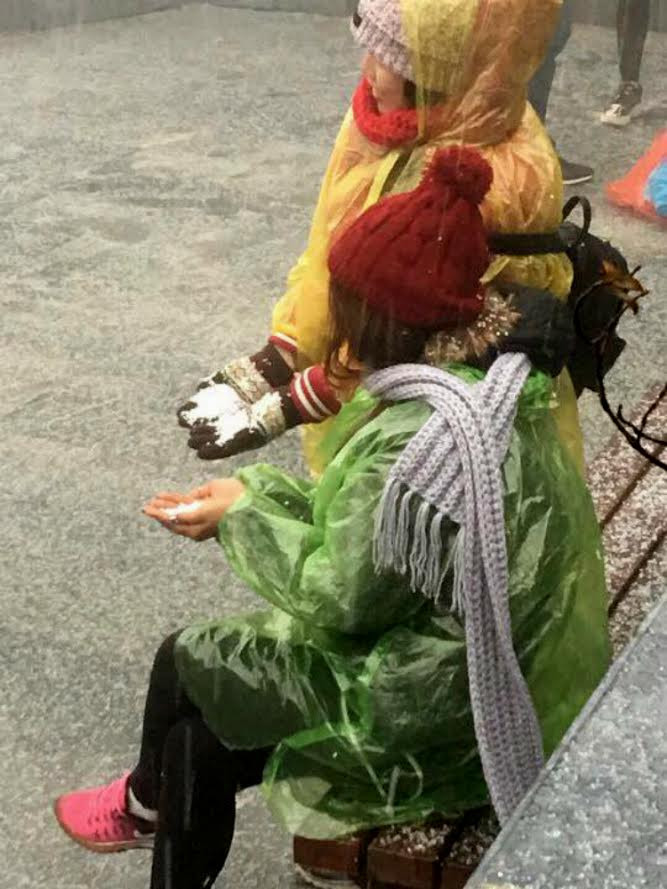 Du khách thích thú hứng những hạt mưa đá rơi. (Nguồn: CTV/Vietnam+)