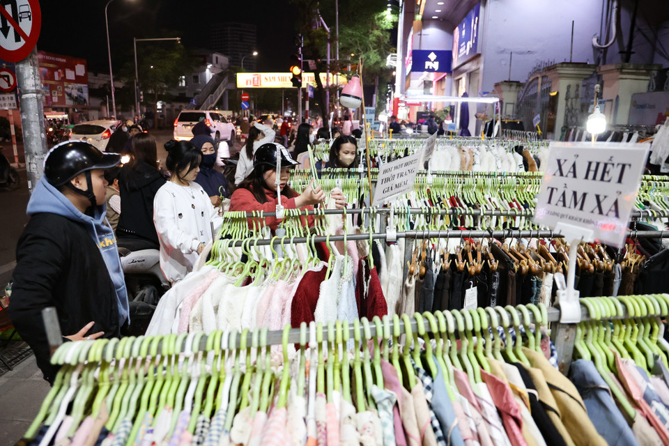 Khách đến mua tại các sạp quần áo treo bên ngoài vỉa hè. (Ảnh: Minh Hiếu/Vietnam+)