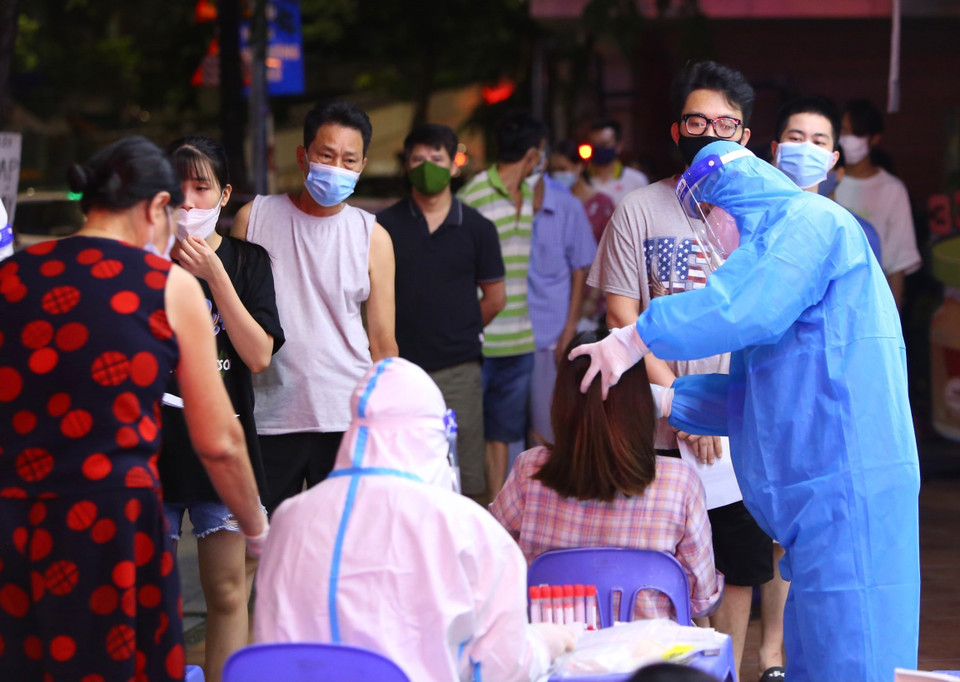 Nhân viên y tế lấy mẫu xét nghiệm cho người dân phường Vĩnh Tuy (quận Hai Bà Trưng) tại điểm lấy mẫu 461 phố Minh Khai. (Ảnh: Hoàng Hiếu/TTXVN)