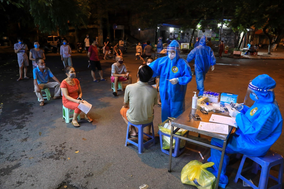 Người dân phường Đội Cấn xếp hàng giãn khoảng cách tuân thủ 5K chờ lấy mẫu xét nghiệm. (Ảnh: Thành Đạt/TTXVN)