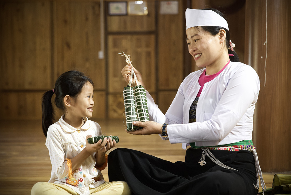 Chị Bùi Thị Chiều ở bản Giang Mỗ, xã Bình Thanh, huyện Cao Phong chia sẻ, việc cùng bố mẹ và các con ngồi gói bánh trong những ngày lễ, Tết luôn mang đến cho chị niềm hạnh phúc và cũng là sự giáo dục cho các thế hệ con cháu cần phát huy và lưu giữ nét đẹp văn hoá của dân tộc. (Ảnh: Trọng Đạt/TTXVN)