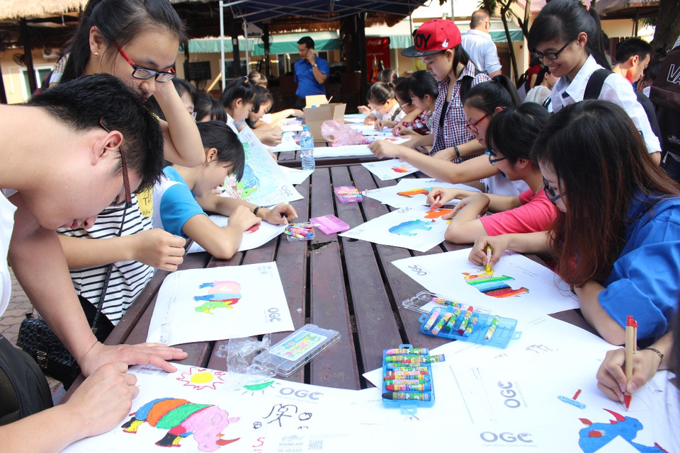 Các bạn trẻ vẽ tranh với các thông điệp có ý nghĩa về bảo vệ động vật hoang dã và nói không với sừng tê giác. (Ảnh: Hùng Võ/Vietnam+)