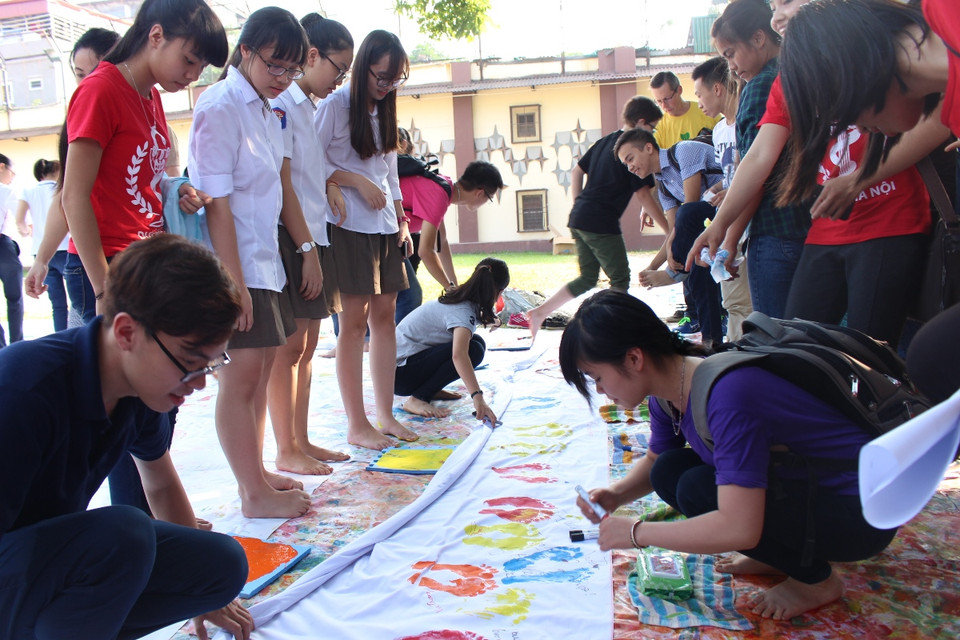 Các đại sứ tê giác đến từ Hoa Kỳ, Nam Phi và bạn trẻ Việt Nam tham gia vào chiến dịch một triệu dấu chân in trên giấy. (Ảnh: Hùng Võ/Vietnam+)