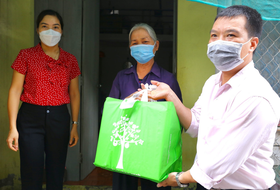 Thay mặt lãnh đạo quận Hà Đông, cán bộ phường Dương Nội trao 30 suất quà cho các gia đình có hoàn cảnh khó khăn. (Ảnh: Hoàng Hiếu/TTXVN)