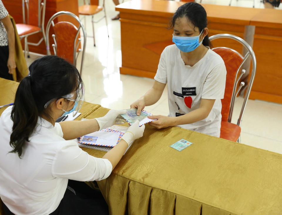 Phường Nguyễn Trãi (quận Hà Đông) tổ chức chi trả tiền hỗ trợ theo NQ 68/NQ-CP cho 100 trường hợp được phê duyệt, với số tiền 1,5 triệu/người (ảnh chụp sáng 12/8). (Ảnh: Hoàng Hiếu/TTXVN)