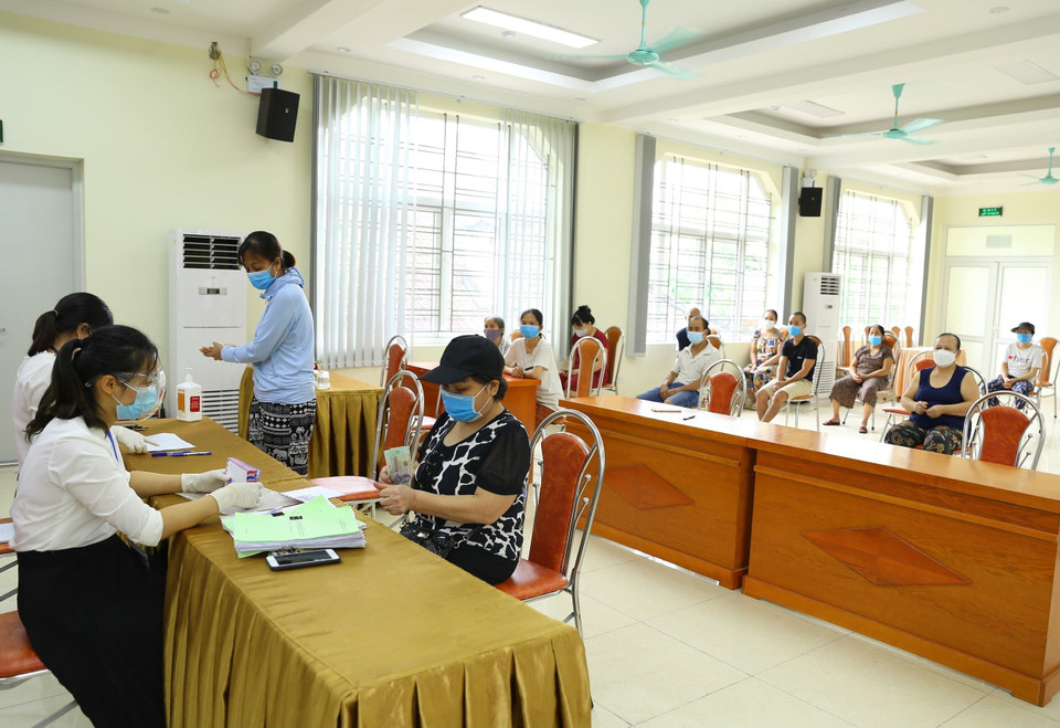 Phường Nguyễn Trãi (quận Hà Đông) tổ chức chi trả tiền hỗ trợ theo NQ 68/NQ-CP cho 100 trường hợp được phê duyệt, với số tiền 1,5 triệu/người (ảnh chụp sáng 12/8). (Ảnh: Hoàng Hiếu/TTXVN)