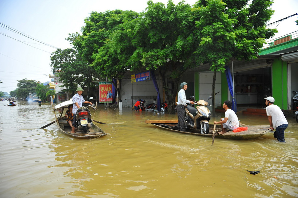 Phương tiện qua QL 477 địa phận xã Lạc Vân, huyện Nho Quan, Ninh Bình, được chở bằng đò. (Ảnh: Minh Đức - TTXVN)