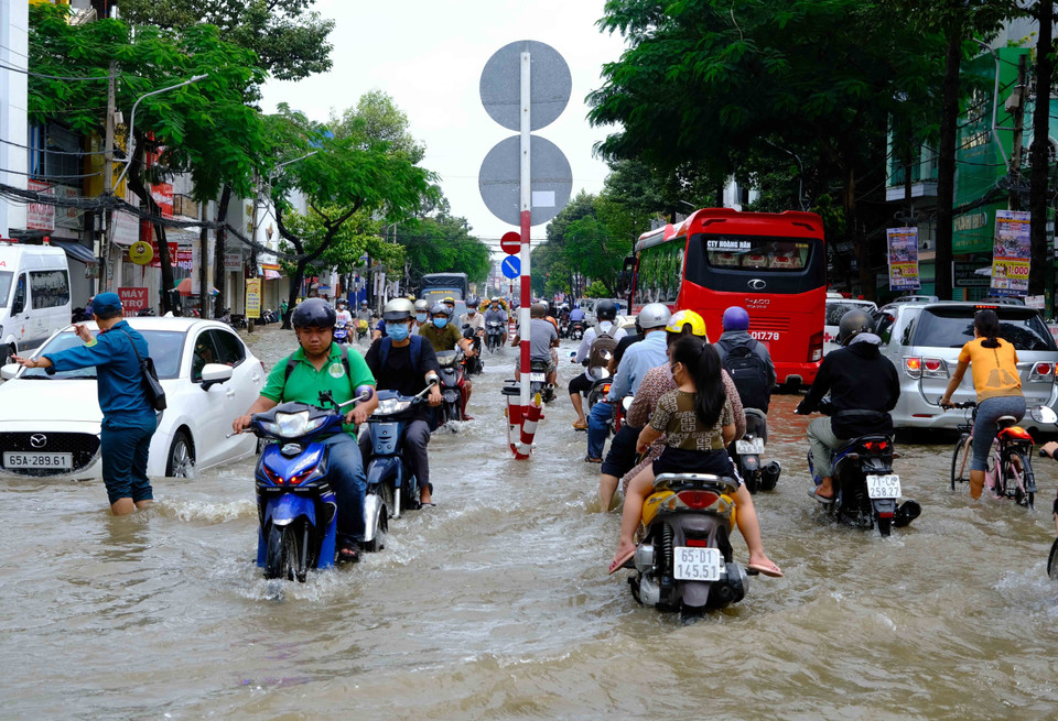 Triều cường dâng cao đã làm ngập nhiều tuyến đường ở khu vực trung tâm thành phố, ảnh hưởng đến giao thông cũng như sinh hoạt của người dân. (Ảnh: Thanh Liêm/TTXVN)