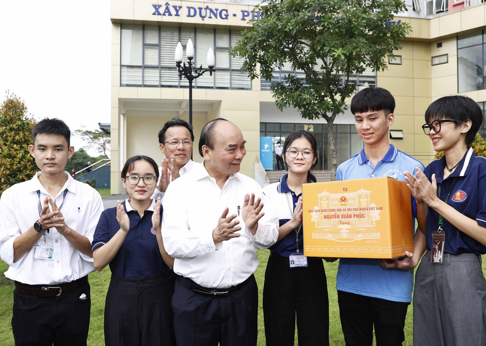 Chủ tịch nước Nguyễn Xuân Phúc tặng quà cho sinh viên Đại học Quốc gia Thành phố Hồ Chí Minh. (Ảnh: Thống Nhất/TTXVN)