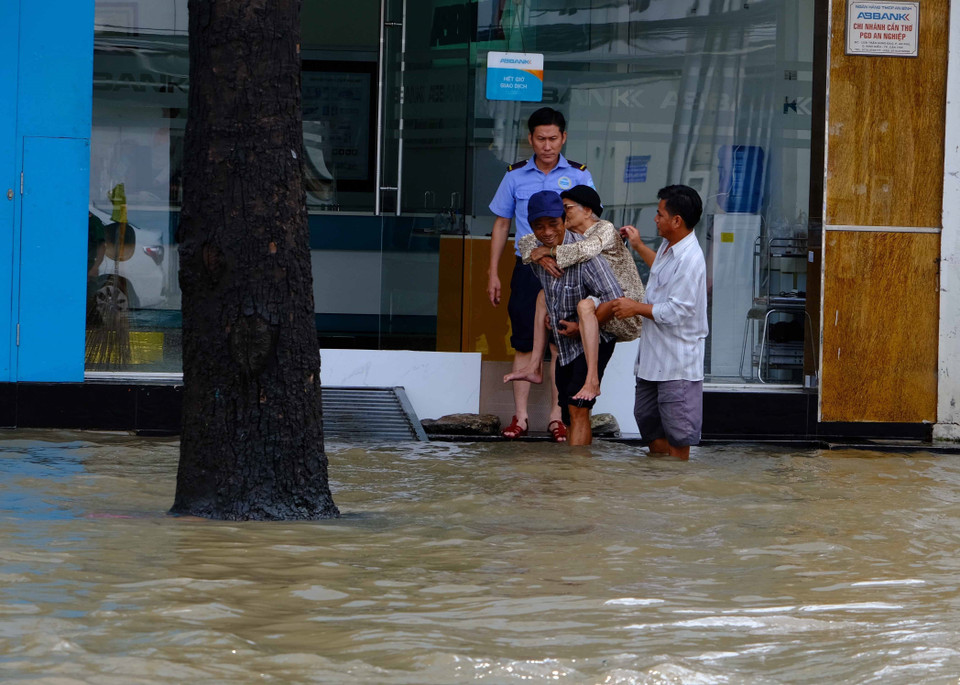 Một cụ bà được người thân cõng đi khám bệnh trên đường Trần Hưng Đạo, thành phố Cần Thơ. (Ảnh: Thanh Liêm/TTXVN)