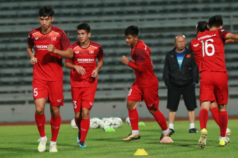 Trong khi các trợ lý cho cầu thủ khởi động, ông thầy người Hàn Quốc lẳng lặng đứng một góc xa theo dõi với ánh mắt trùng xuống. (Ảnh: Nguyên An/Vietnam+)